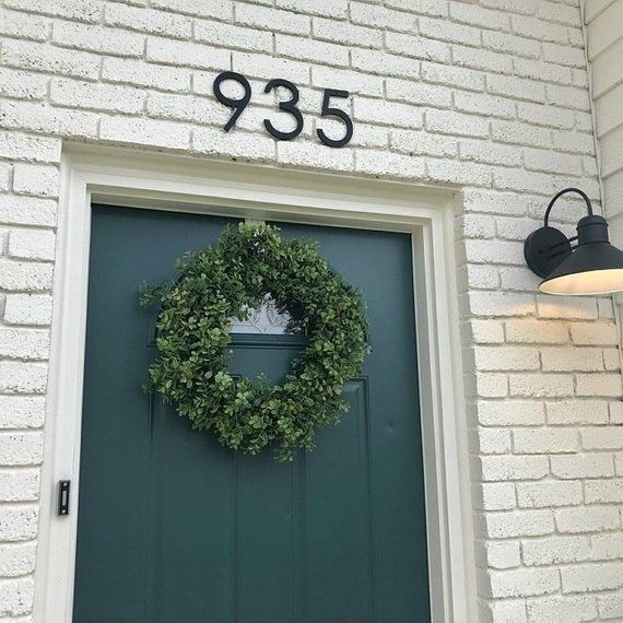 A front door showcasing the house number '935' in a large sans-serif font, adding a contemporary touch to the entryway.
