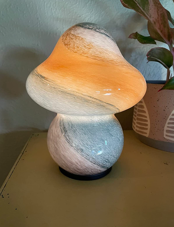 A mushroom-shaped lamp in white, accented with vibrant streaks of color throughout.