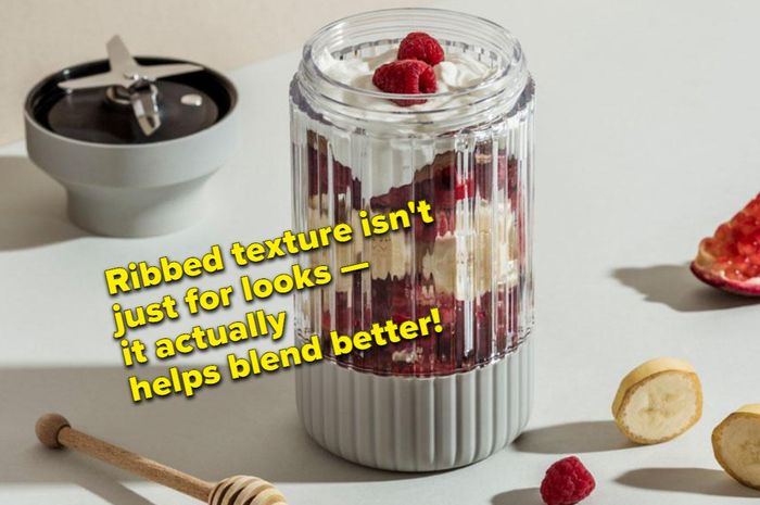 The blender jar filled with a mix of berries, yogurt, and other fruits.