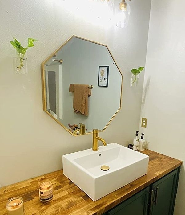 Reviewer photo of a gold mirror hanging above a bathroom sink.
