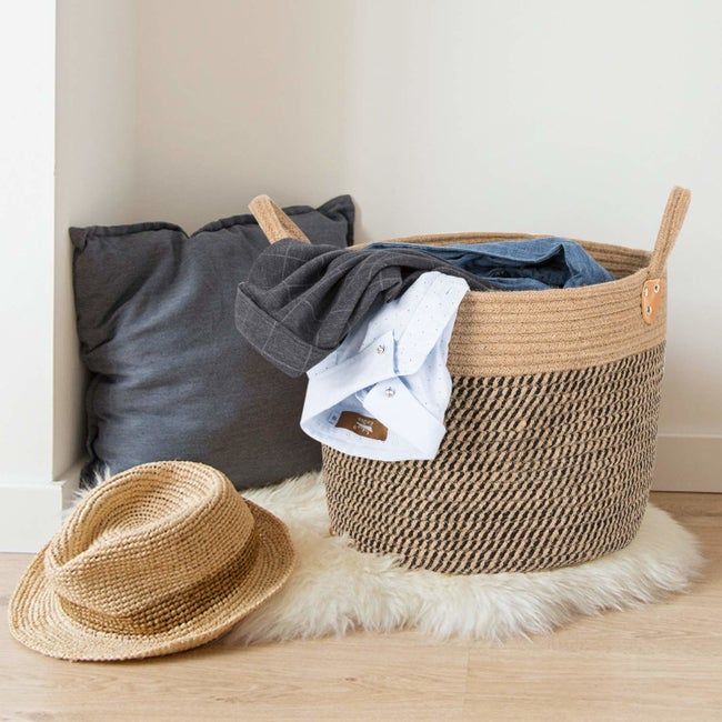 The jute basket filled with dirty laundry.