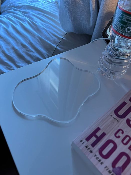The clear version of the coaster resting on a nightstand, simple yet elegant.