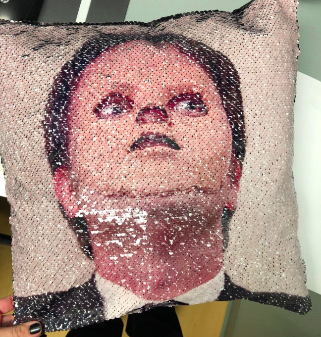 A photo submitted by a customer showing the pillow featuring Dwight from The Office donning the fake skin mask.