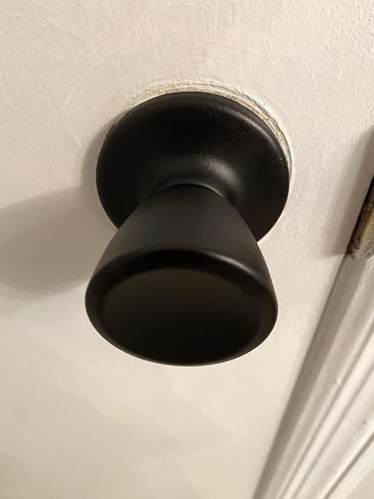 The same knob after being spray-painted in a sleek metallic black, giving it a modern and refreshed look.