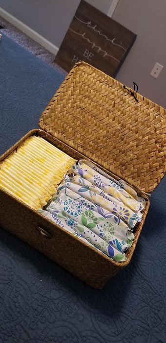 A basket, open and filled with pads and tampons.