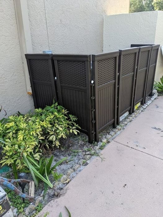 Brown privacy screen panels concealing a reviewer’s air conditioning unit.