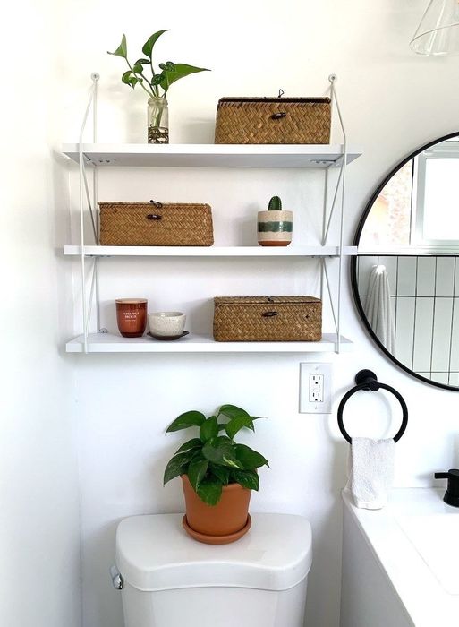 The reviewer's shelf positioned above the toilet, with brown woven lidded baskets placed neatly on each level.