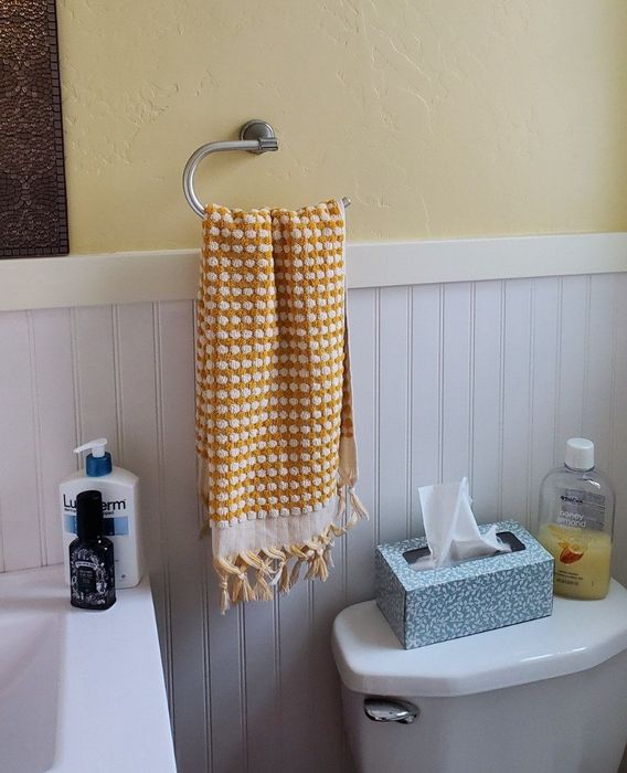 The towel in cheerful yellow and white, brightening up the space with its sunny hues.