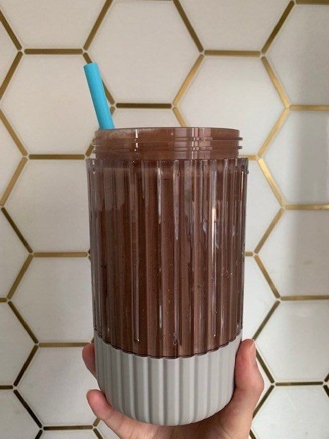 My hand holding the jar filled with the smoothie