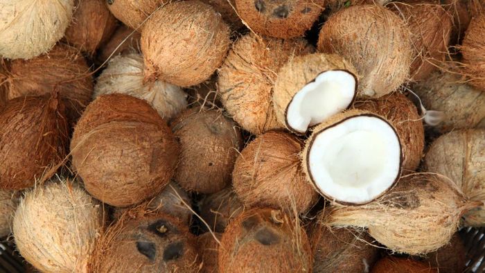 A heap of coconuts, with one cracked open
