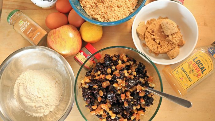 Dried fruit, sugar, and butter arranged on a table for cake preparation.