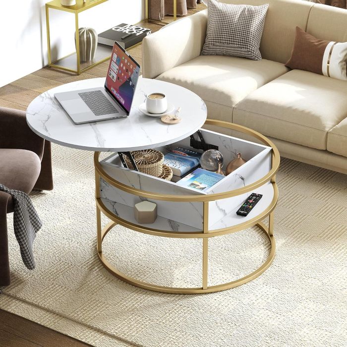 A round marble coffee table with a golden frame and a lower shelf, adorned with decorative items that add a touch of class and style
