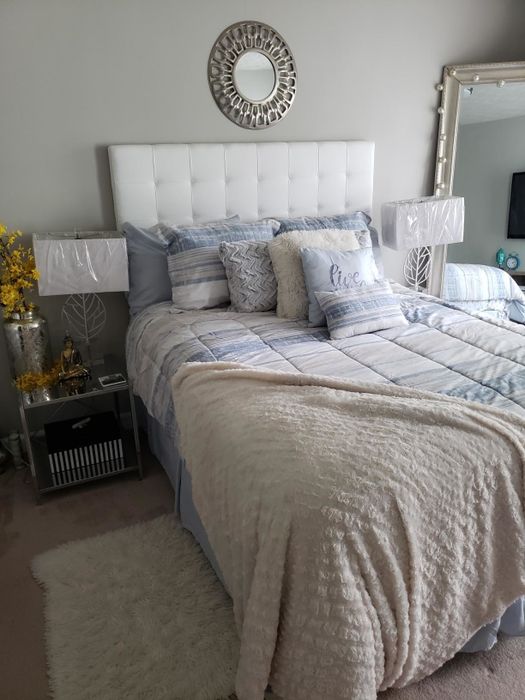 A reviewer's white tufted headboard shown in a tranquil bedroom setting.