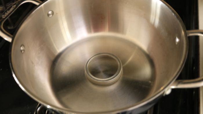 A mason jar ring placed inside a pot.