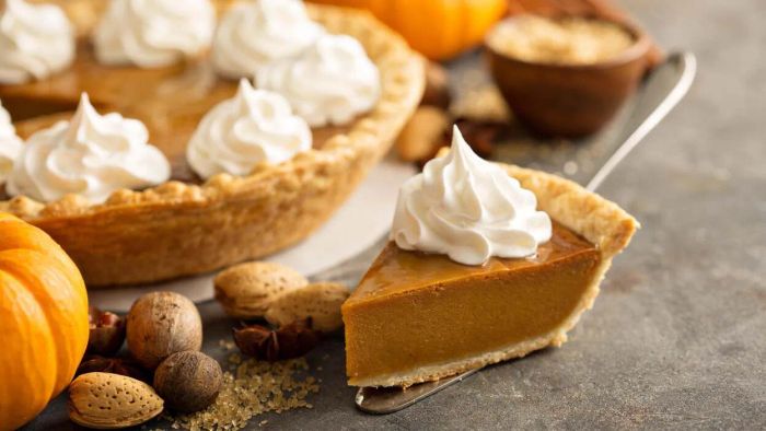 A slice of pumpkin pie topped with a generous dollop of whipped cream.