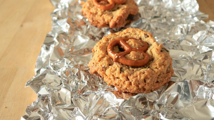 Two cookies rest on a crinkled sheet of foil.