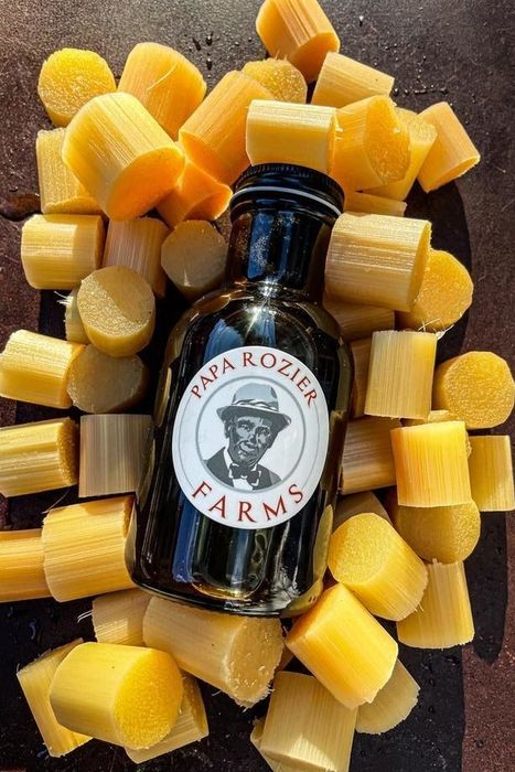 A bottle of pure cane sugar surrounded by chunks of solid cane, offering a natural sweetness for any treat.