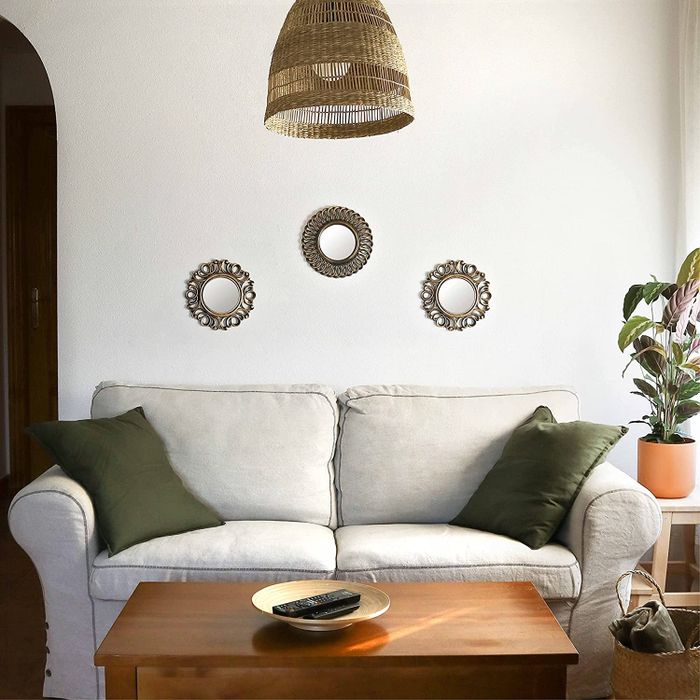 The bronze starburst mirrors hanging over a couch.