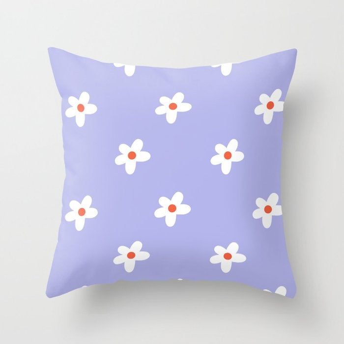 A purple throw pillow featuring a white floral design.
