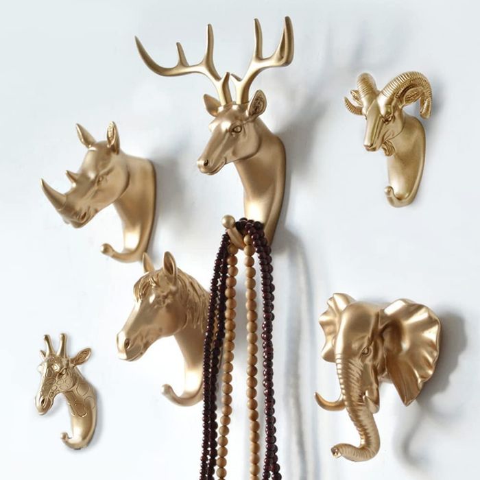 Faux gold animal-shaped wall hooks featuring a rhino, deer, ram, horse, elephant, and giraffe.