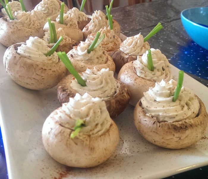 Image of stuffed mushrooms garnished with chive blades standing tall