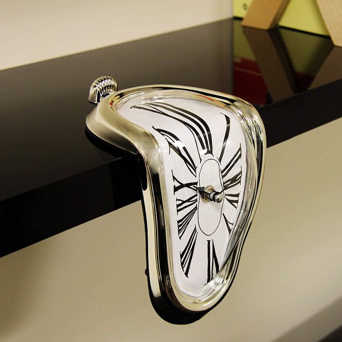 A surrealist melting Dalí clock resting on a shelf.