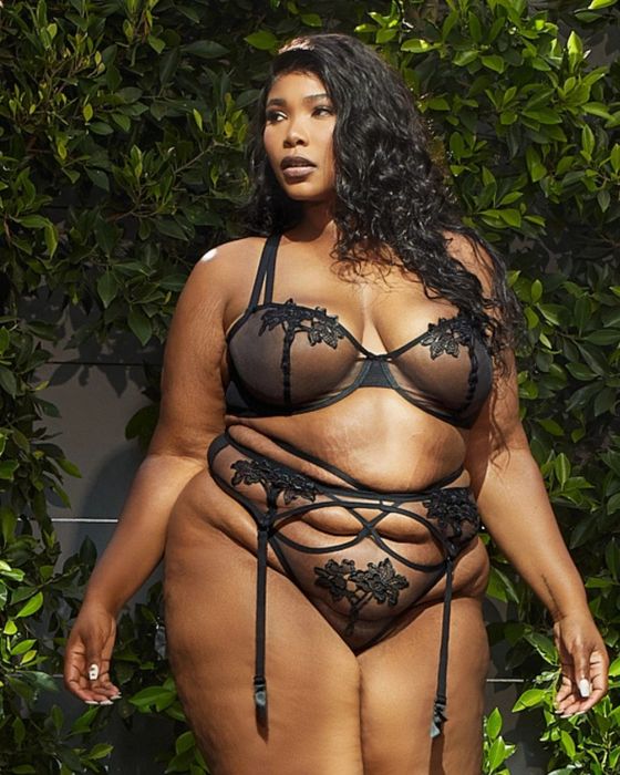 A model showcasing a sheer lace bra and panties with intricate wrapping details along the stomach, adding a touch of sensuality.