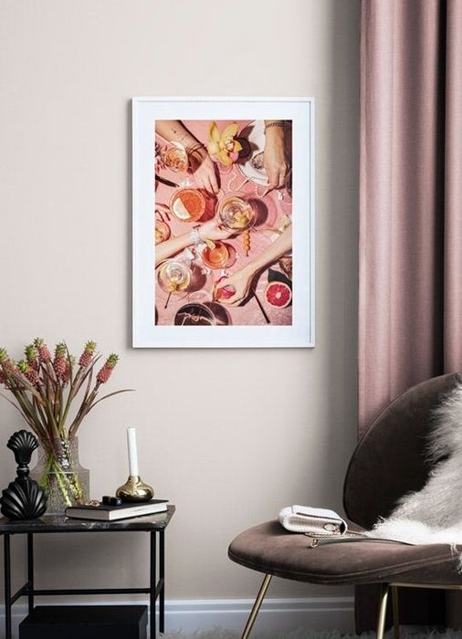 A cocktail print displayed above an accent chair.
