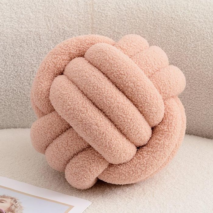 A soft, pink knot pillow that adds charm to any room.