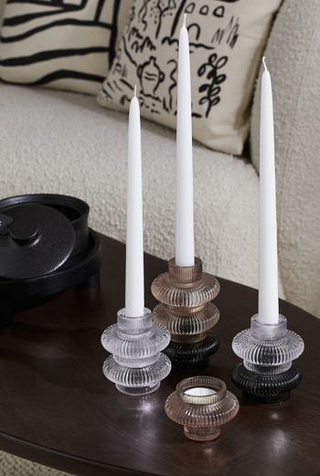 Candle holders available in clear and beige colors.