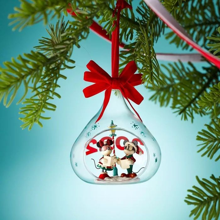 The Mickey and Minnie ornament hanging from a Christmas tree.
