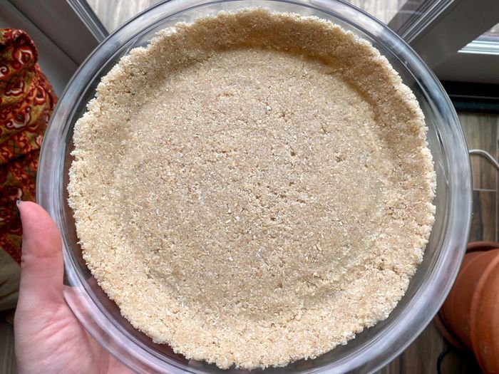 The almond-oat crust pressed into the pie plate, ready for baking.