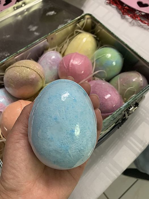 A reviewer holding the giant dinosaur bath bomb.
