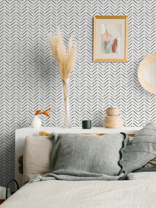 The black and white chevron wallpaper above a bed, adding a bold and modern touch.