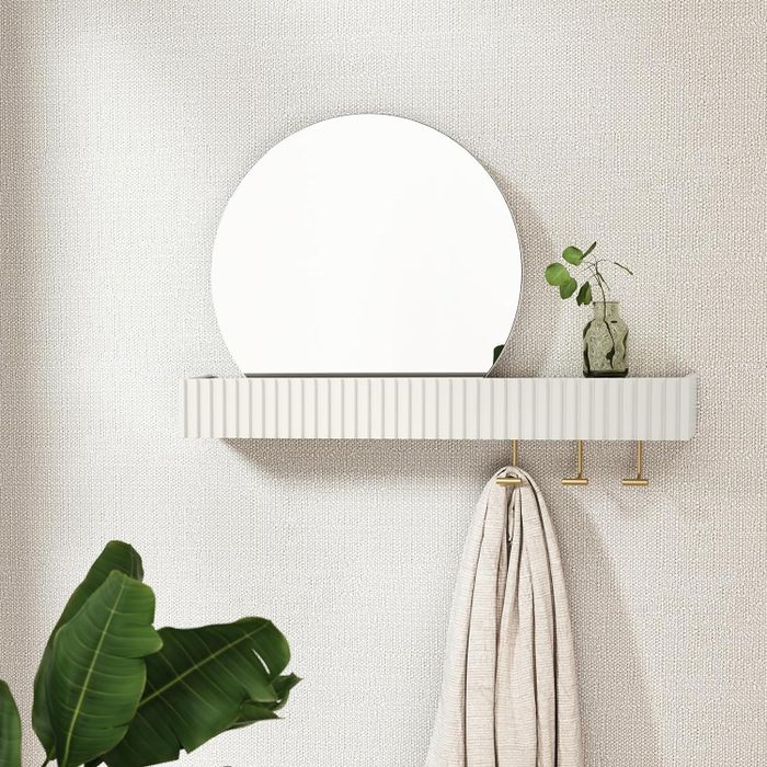 the mirror and shelf installed on a textured wall