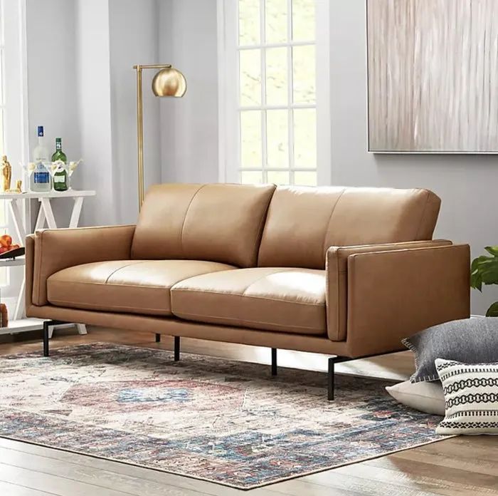 A brown leather sofa, beautifully styled in a cozy living room setting, adding a touch of sophistication.