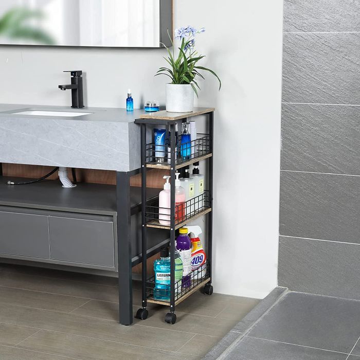 A black slim cart placed next to a bathroom sink, holding various toiletries in an organized manner.