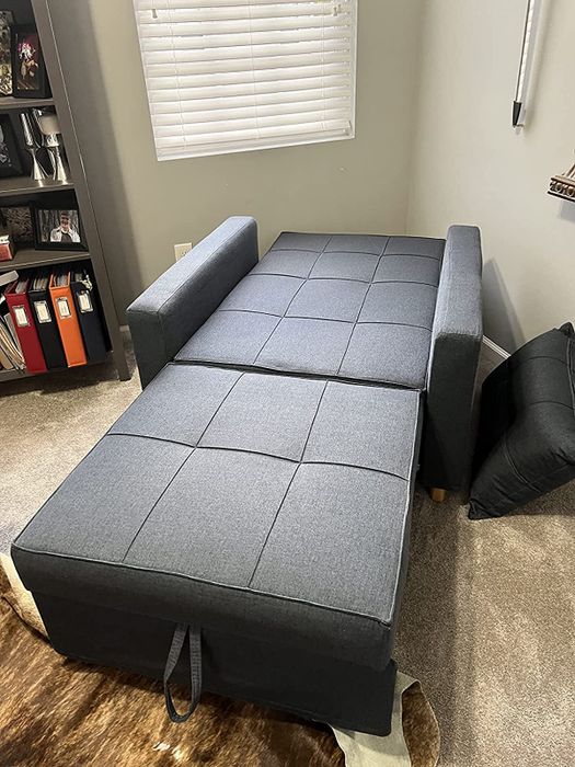 The same navy chair in its extended sleeper sofa position as demonstrated by the reviewer.
