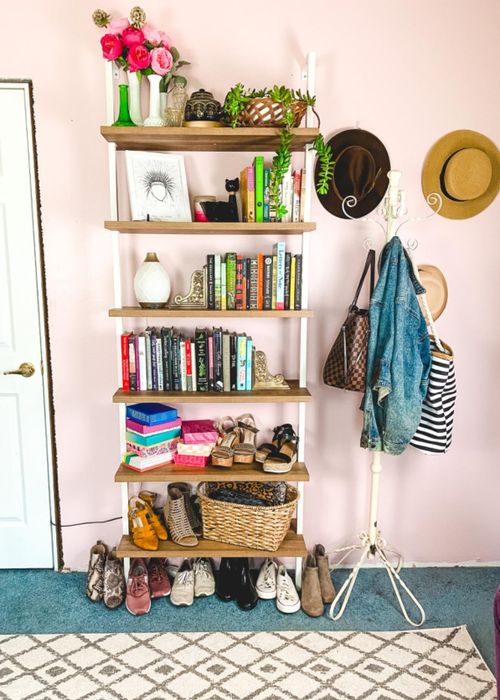 A reviewer's oak and white shelf holding books, shoes, and other miscellaneous items.