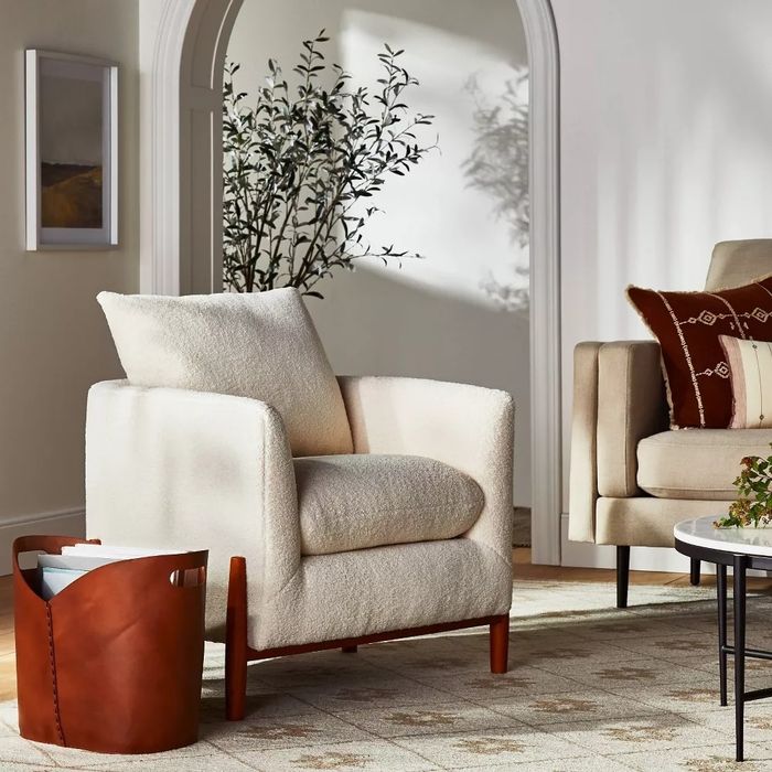 The cream-colored linen accent chair placed in a cozy living room.