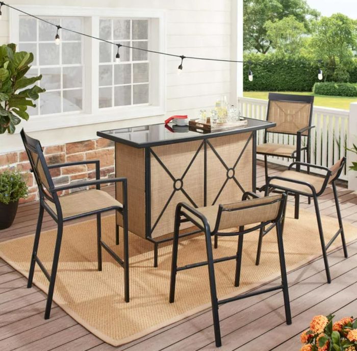 A spacious outdoor bar table surrounded by stools and chairs.
