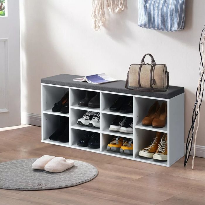 A white and grey shoe storage bench that holds up to 10 pairs of shoes.