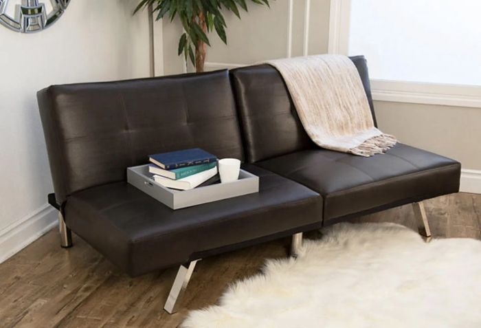 A convertible futon in black, perfectly styled in a cozy living room setting.