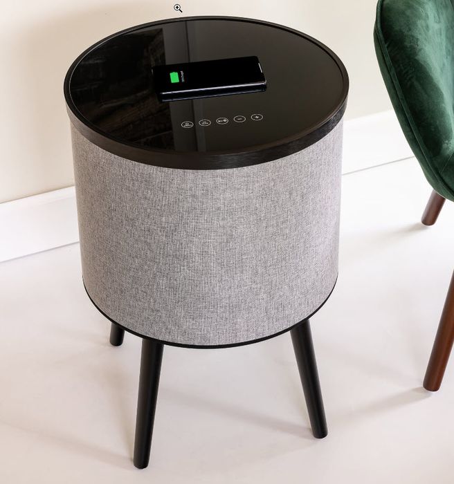 A standing speaker with an integrated charging table.