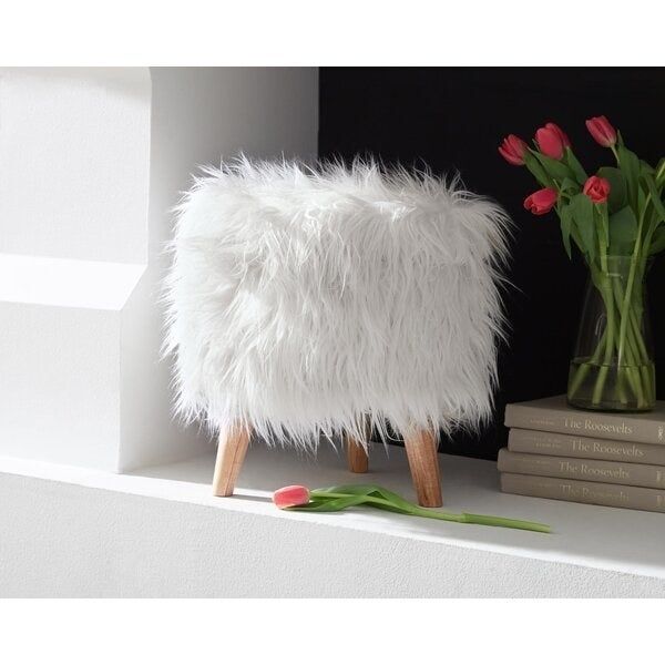 The extra-fluffy white faux fur storage ottoman with legs.