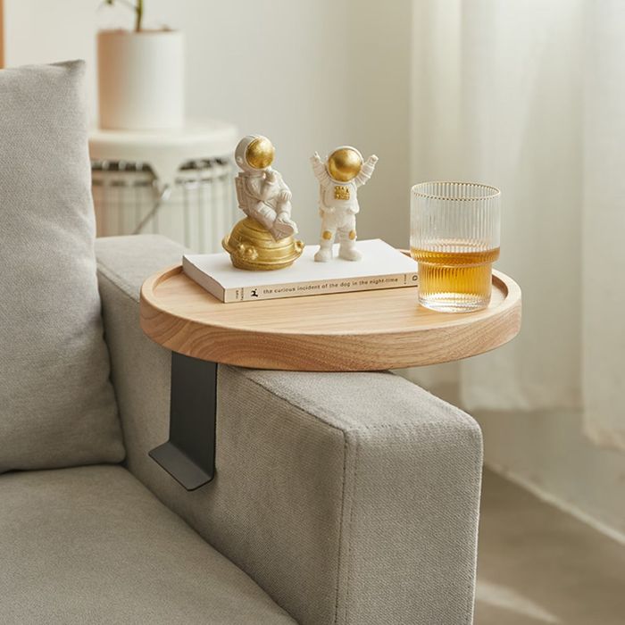 The wooden clip-on table, attached to a sofa arm, holding a drink in place.