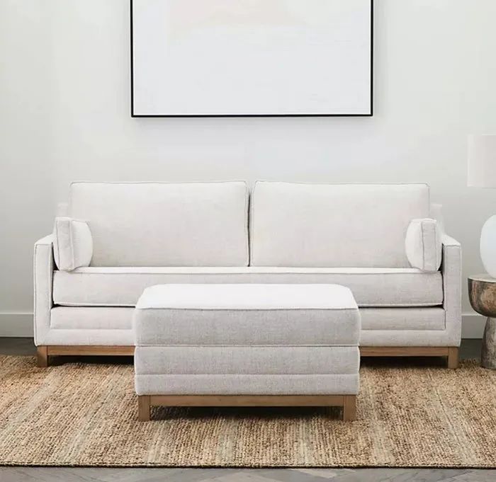 A well-crafted upholstered sofa paired with a matching ottoman for a seamless look.