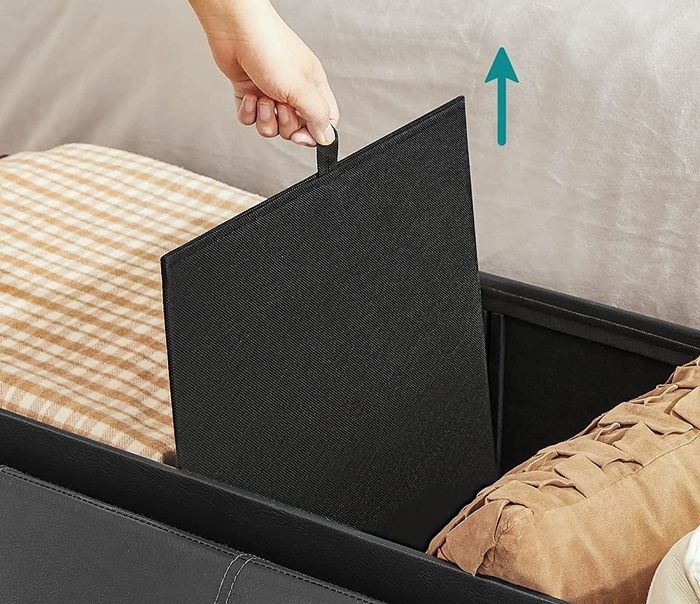 A model pulling out the divider from the storage ottoman
