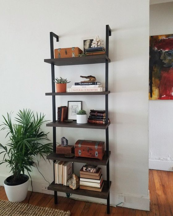 A reviewer's bookshelf in warm walnut and black finishes.