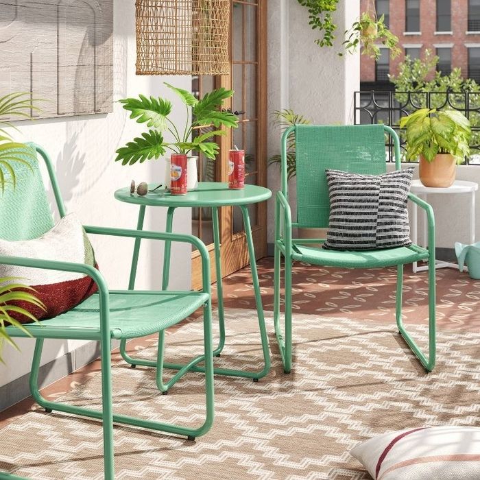 A green patio dining set shown outdoors